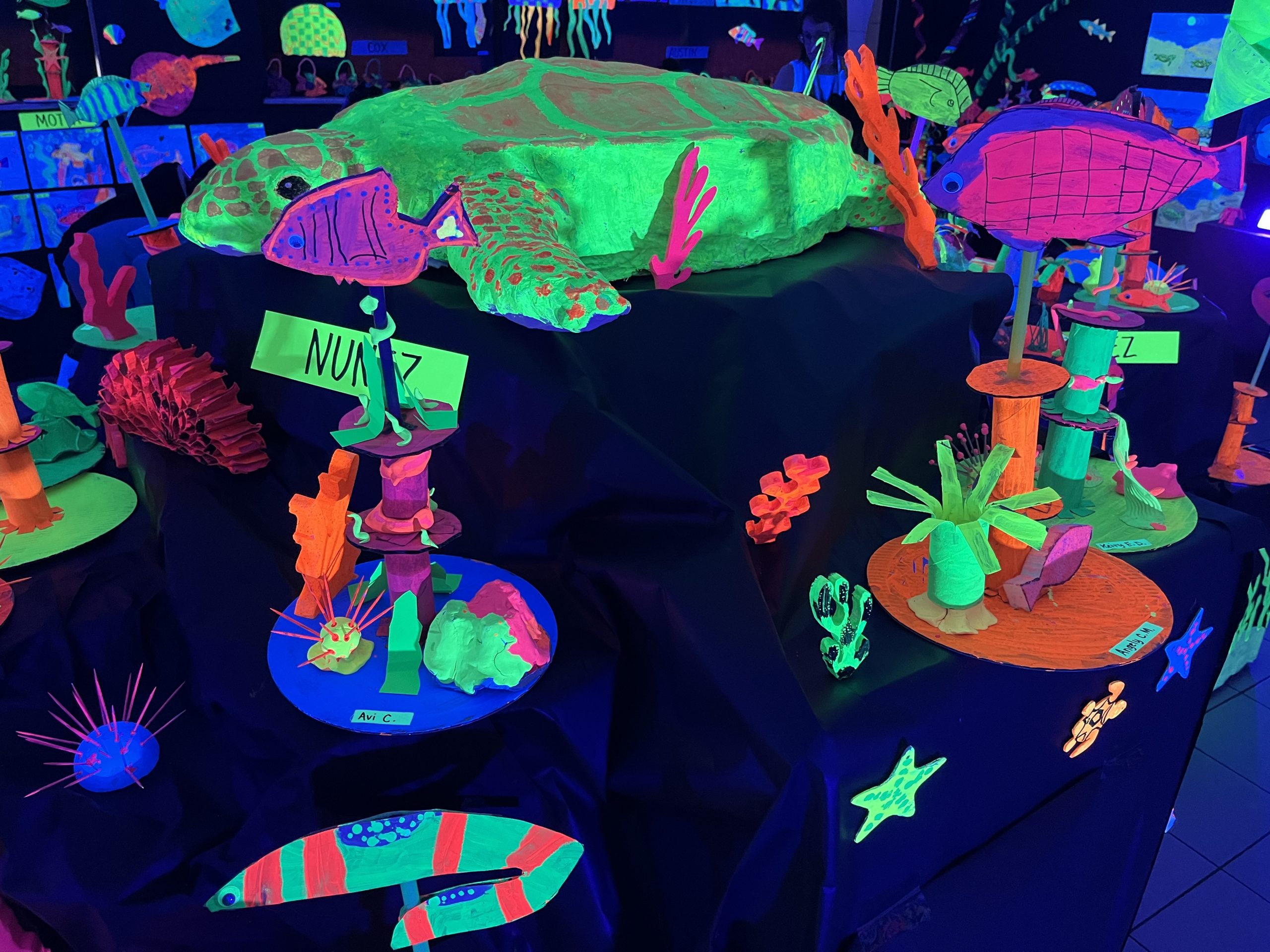 Neon sea turtle sculpture with other fish and coral structures