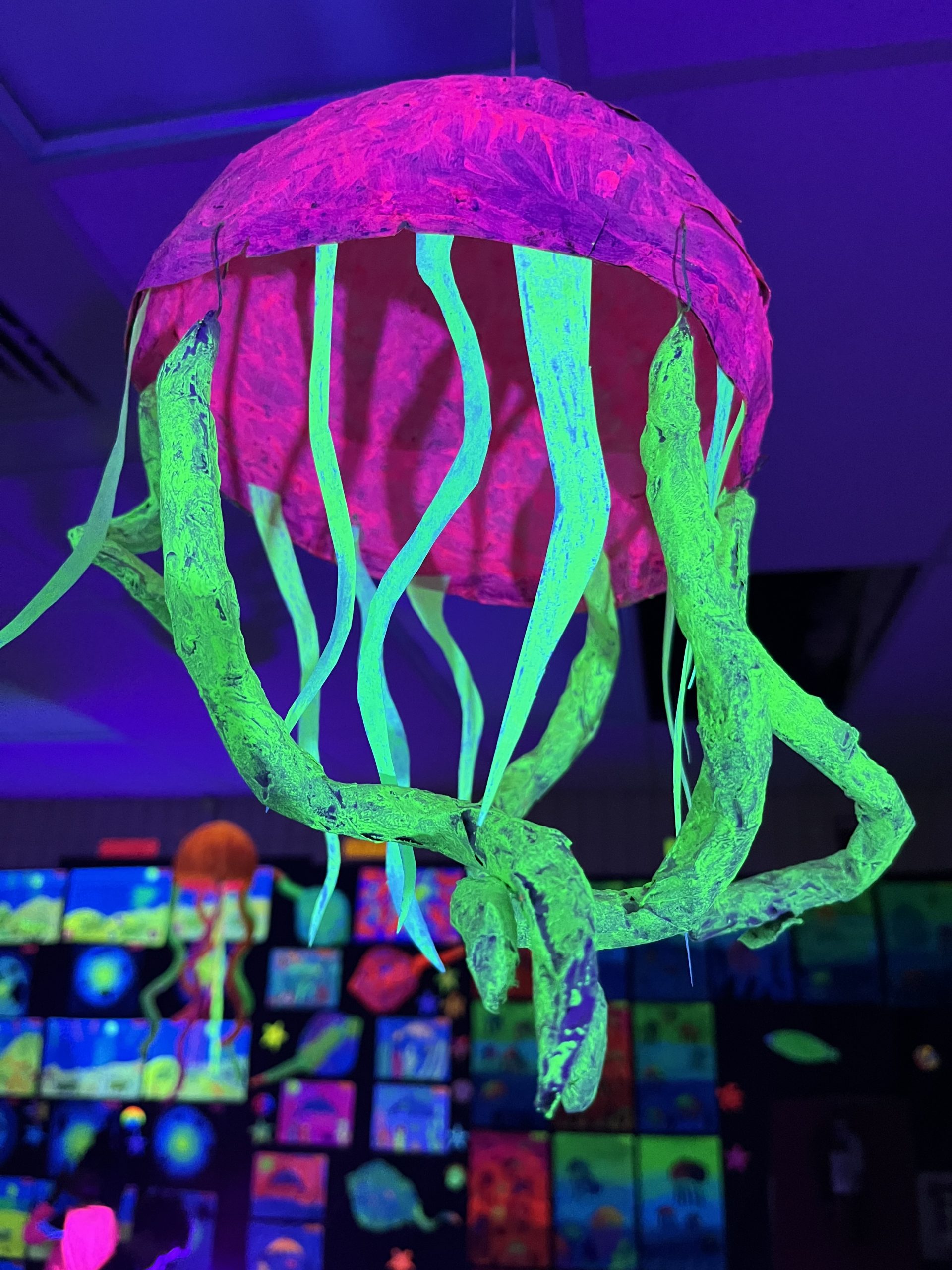 Fluorescent jellyfish sculpture hanging from the ceiling